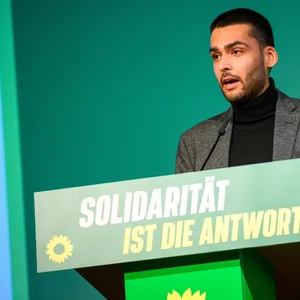 Leon Alam, stellvertretender Landesvorsitzender von Bündnis 90/Die Grünen in Hamburg, spricht während des Landesparteitags auf der Bühne im Bürgerhaus Wilhelmsburg.