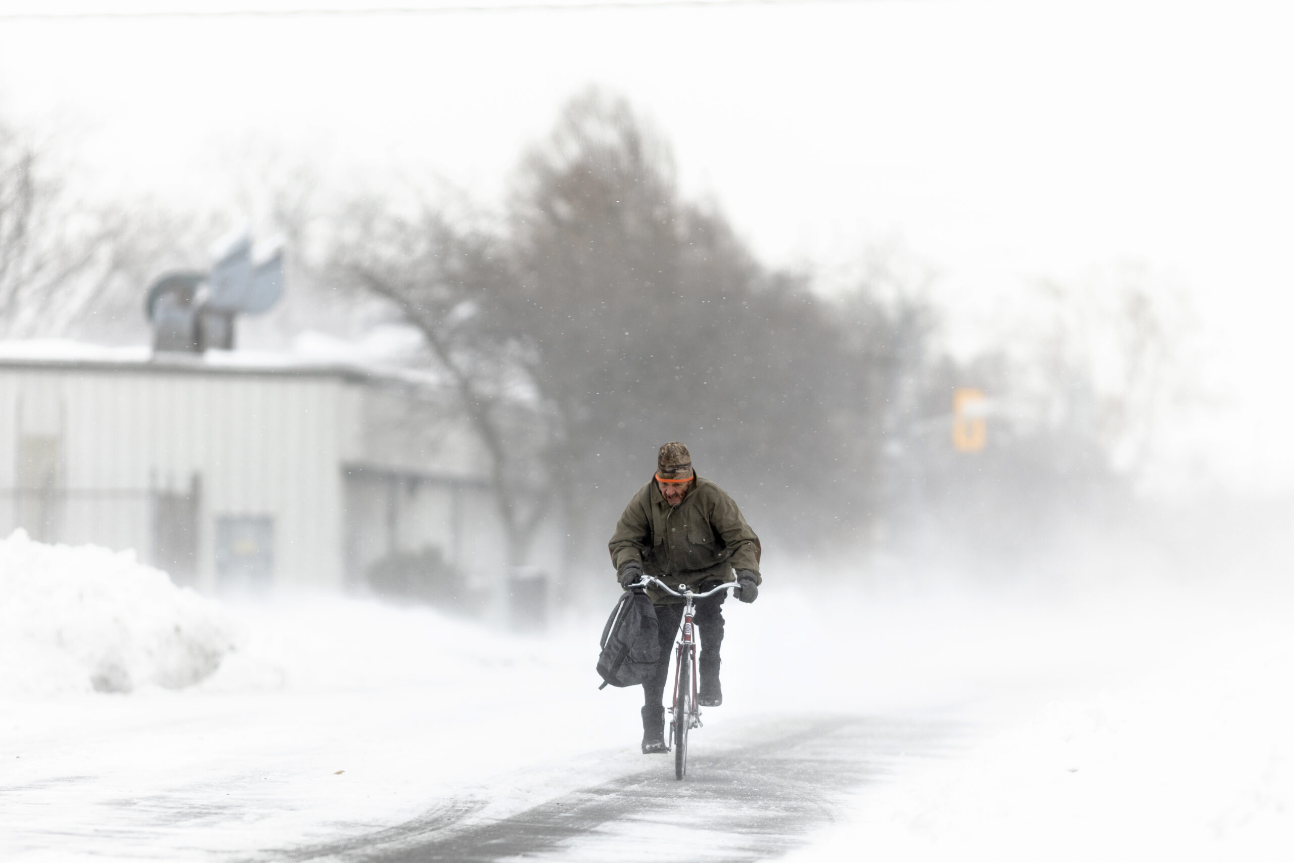 Ein Mann fährt während des Schneesturms im Nordosten der USA eine schneebedeckte Straße entlang.