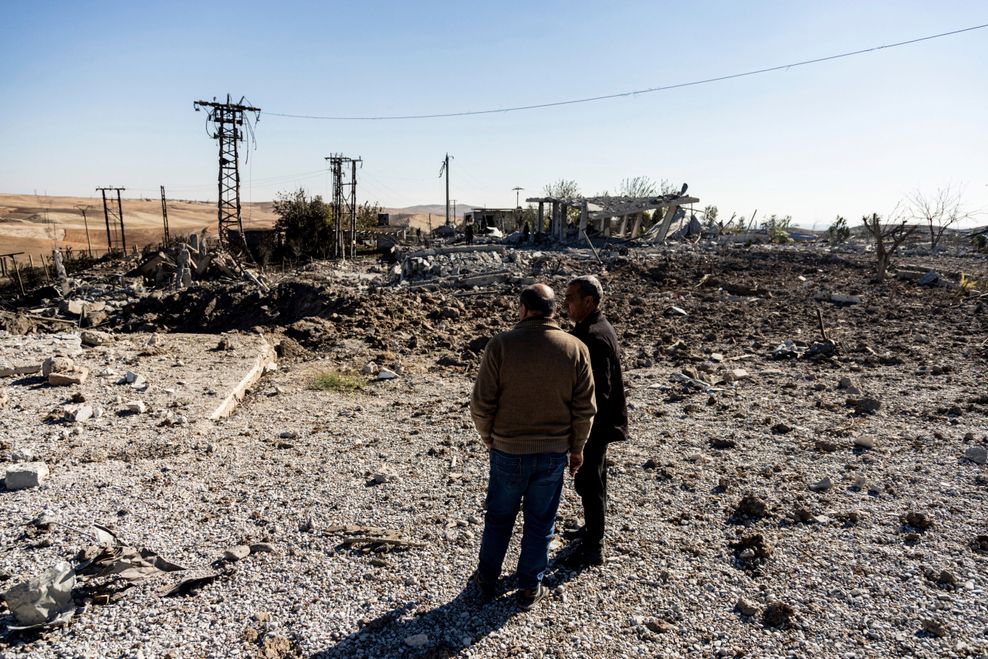 Menschen betrachten einen Ort in Nordsyrien, der durch türkische Luftangriffe beschädigt wurde, die ein Elektrizitätswerk getroffen haben.