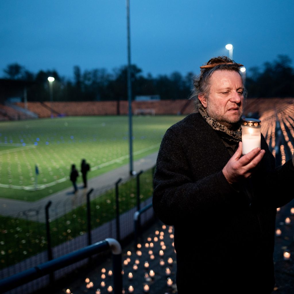 Der Künstler Volker-Johannes Trieb steht bei der Protestaktion auf dem Rasen des Stadions am Schloss Strünkede.