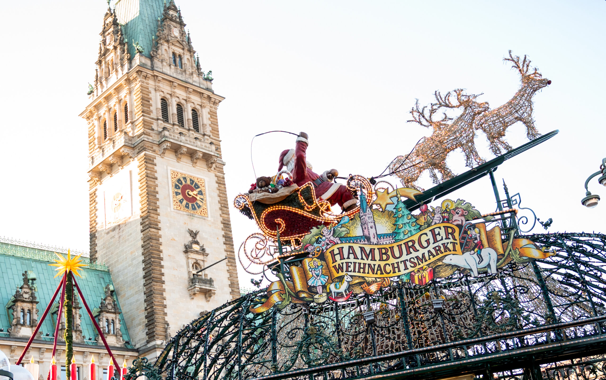 Eine Weihnachtsmannfigur mit Rentieren vor dem Hamburger Rathaus