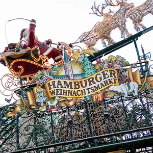 Eine Weihnachtsmannfigur mit Rentieren vor dem Hamburger Rathaus
