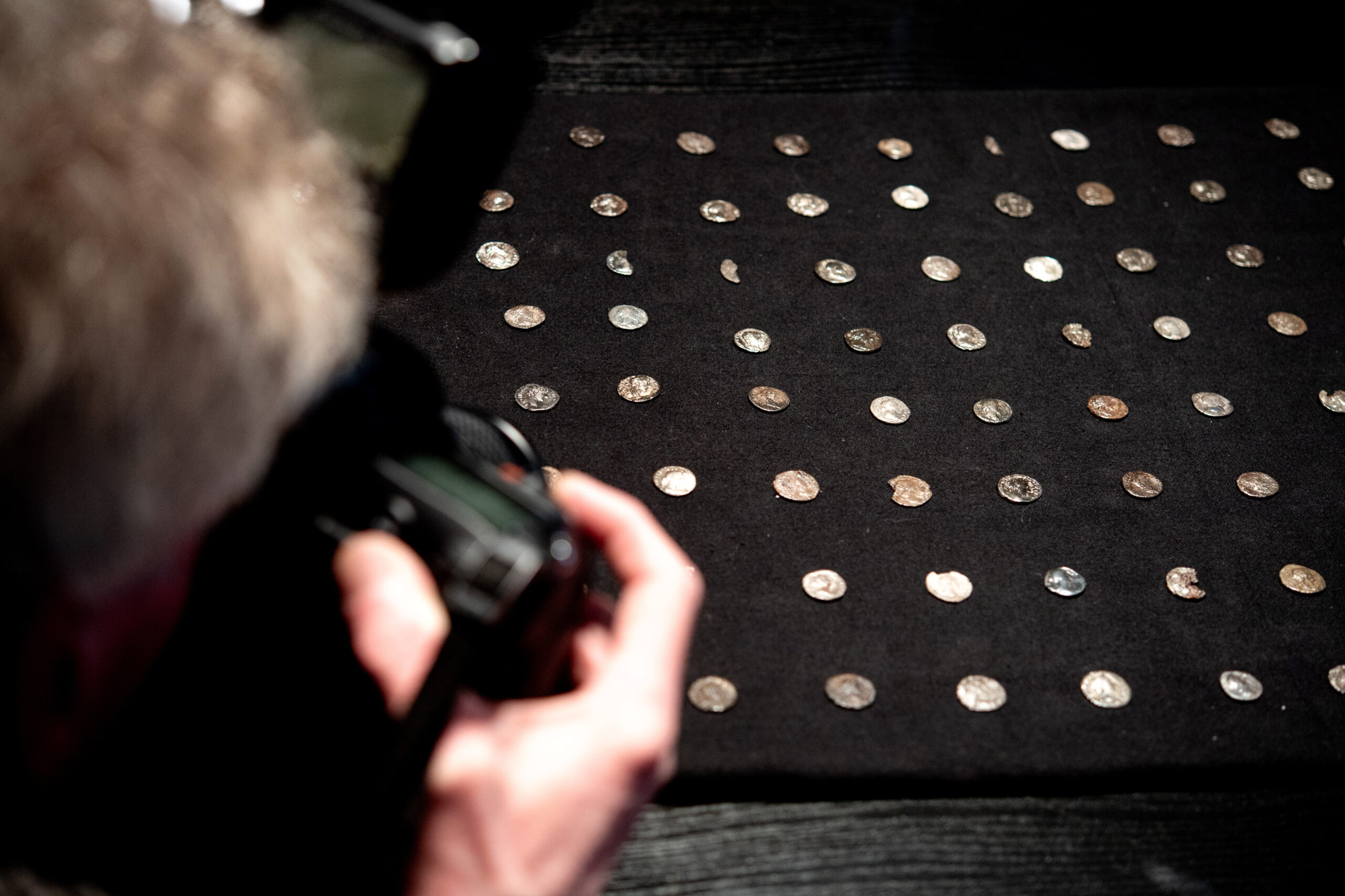 Mehrere Silbermünzen aus der römischen Kaiserzeit liegen auf einem Tisch