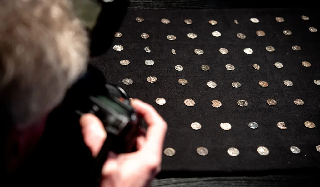 Mehrere Silbermünzen aus der römischen Kaiserzeit liegen auf einem Tisch