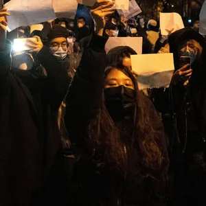 Demonstranten halten leere Papiere hoch, während sie protestieren. In China hat die strenge Corona-Politik am Wochenende zu den größten Protesten seit Jahrzehnten geführt.
