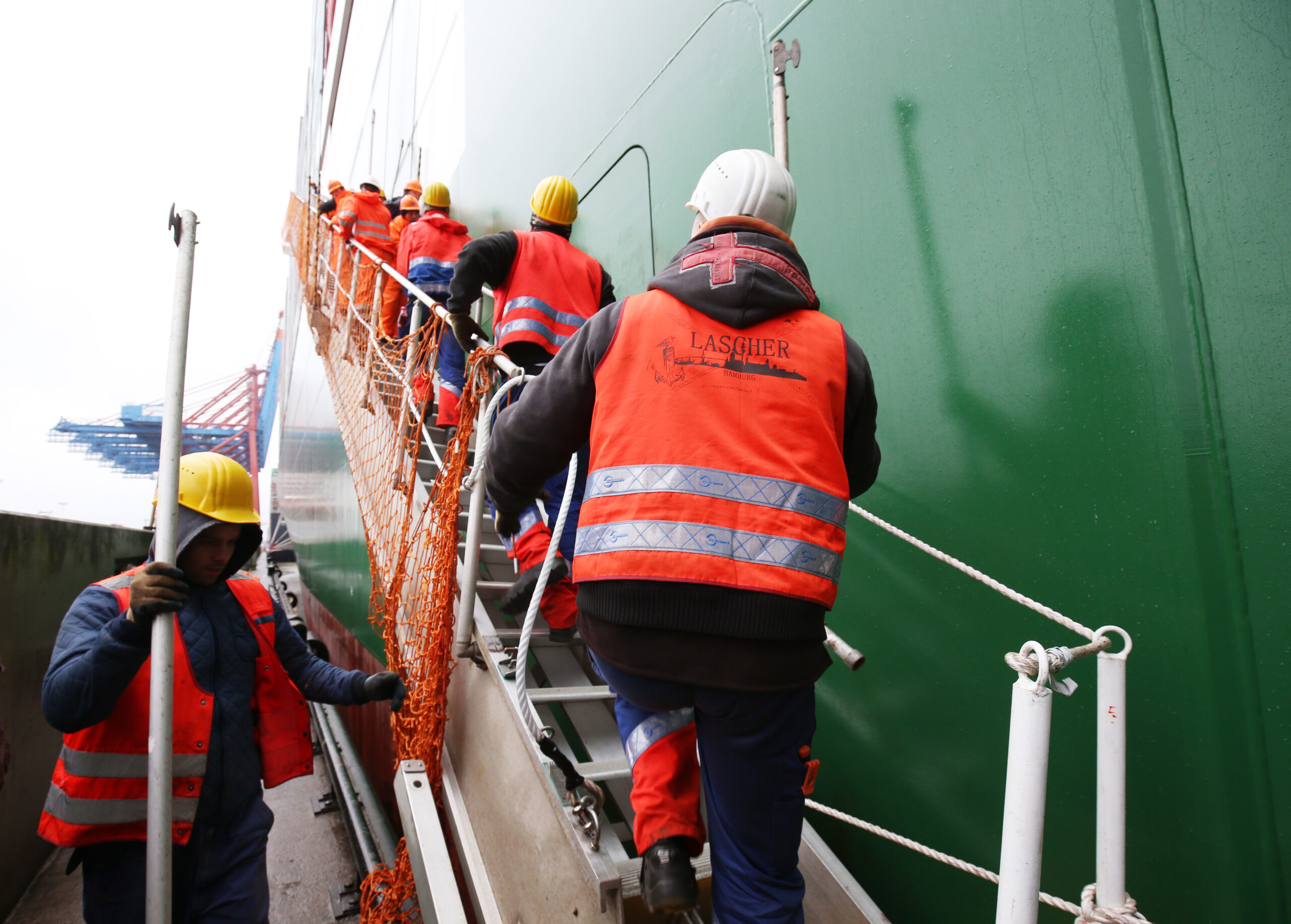 Verladearbeiter (Lascher) gehen an Bord eines Containerschiffs