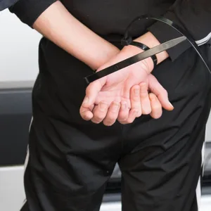 Ein junger Mann wird von Polizisten abgeführt