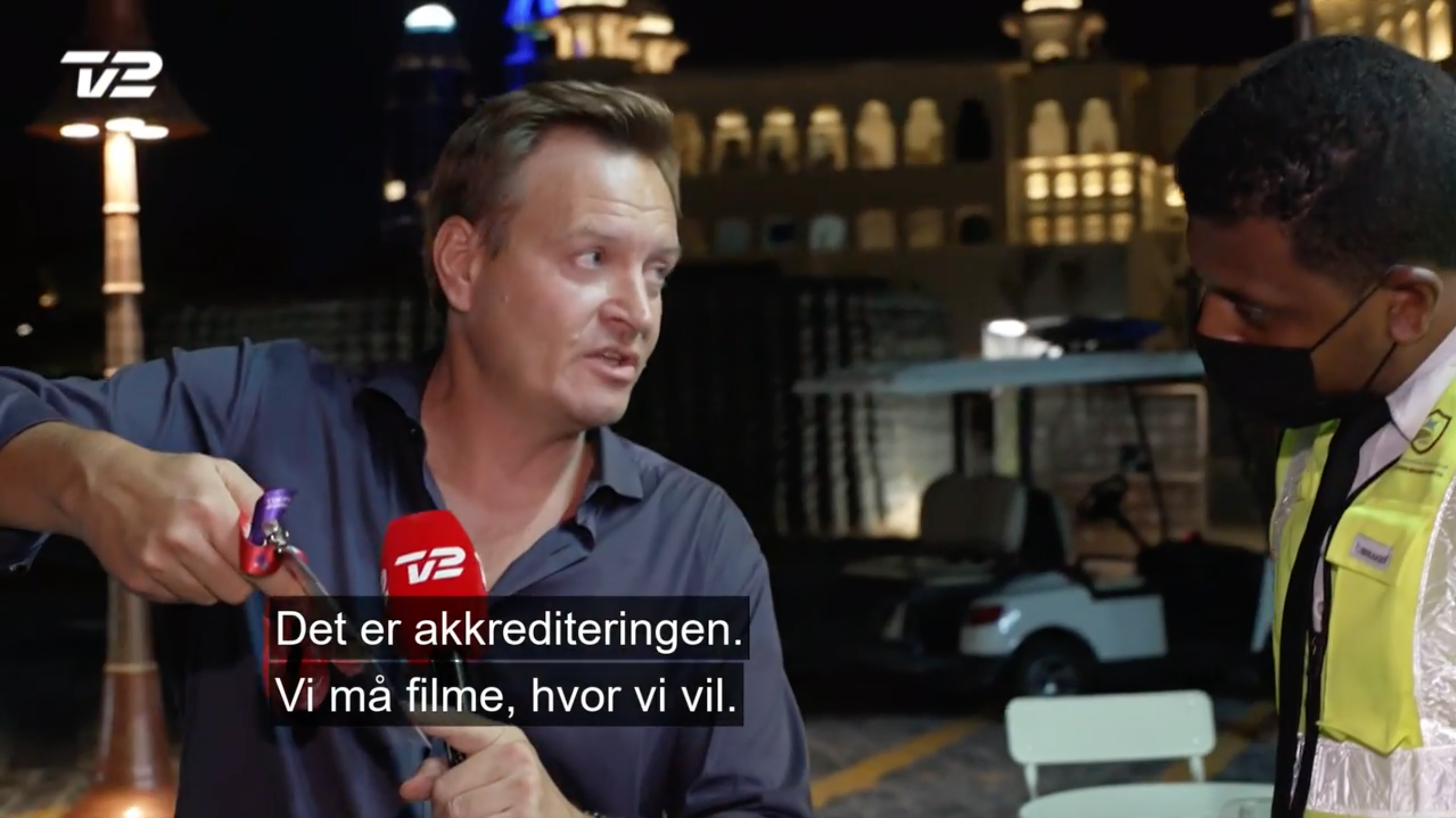 Der Dänische Journalist Rasmus Tantholdt zeigt Sicherheitskräften seine Akkreditierung.
