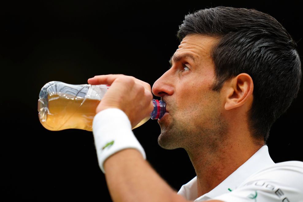 Novac Djokovic trinkt aus einer Flasche.