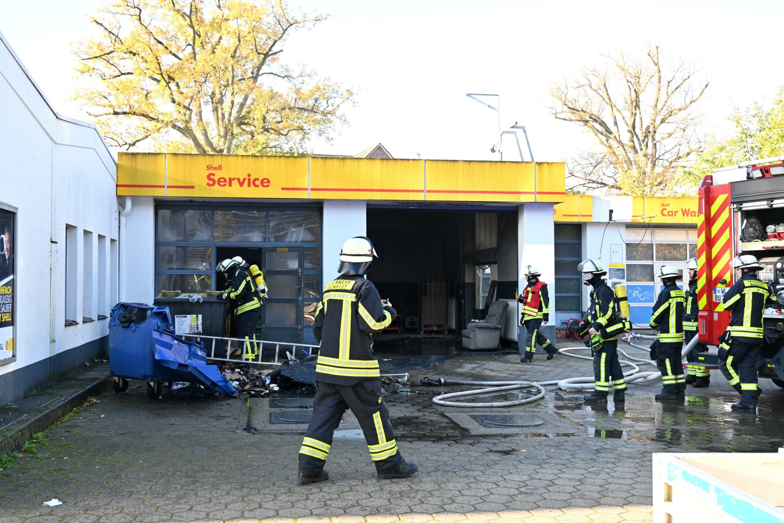 Feuerwehrmänner stehen auf dem Gelände einer Tankstelle in Buchholz, wo ein Feuer ausgebrochen war
