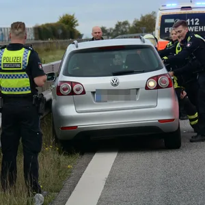 Polizeikräfte schieben den Wagen von der Planke weg.