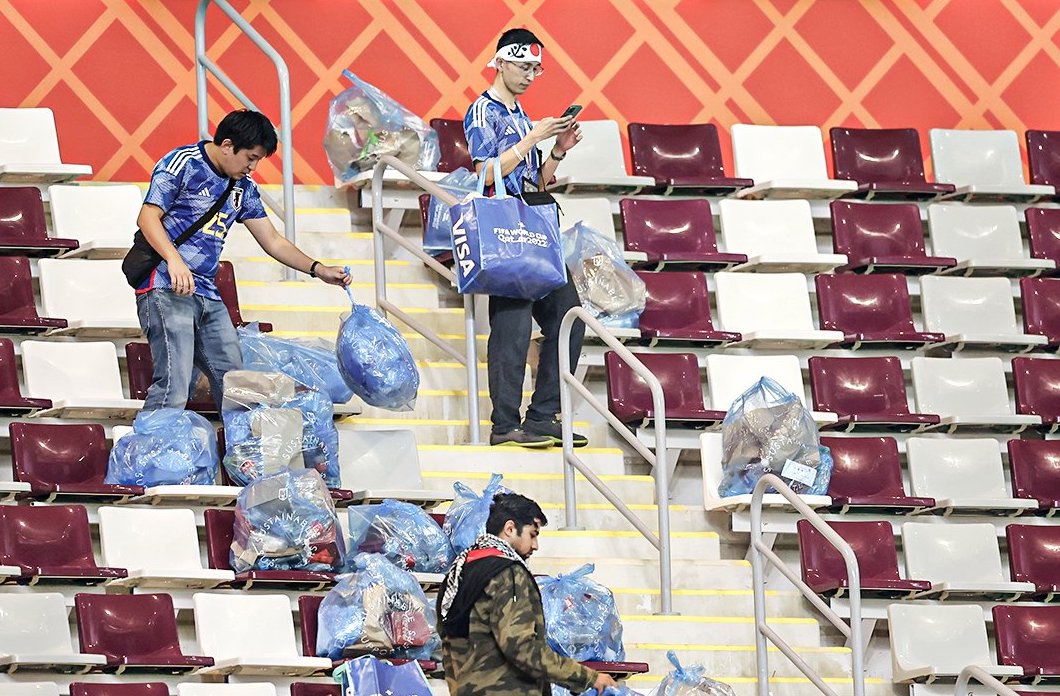 Japanische Fans sammeln Müll im Stadion