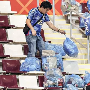 Japanische Fans sammeln Müll im Stadion