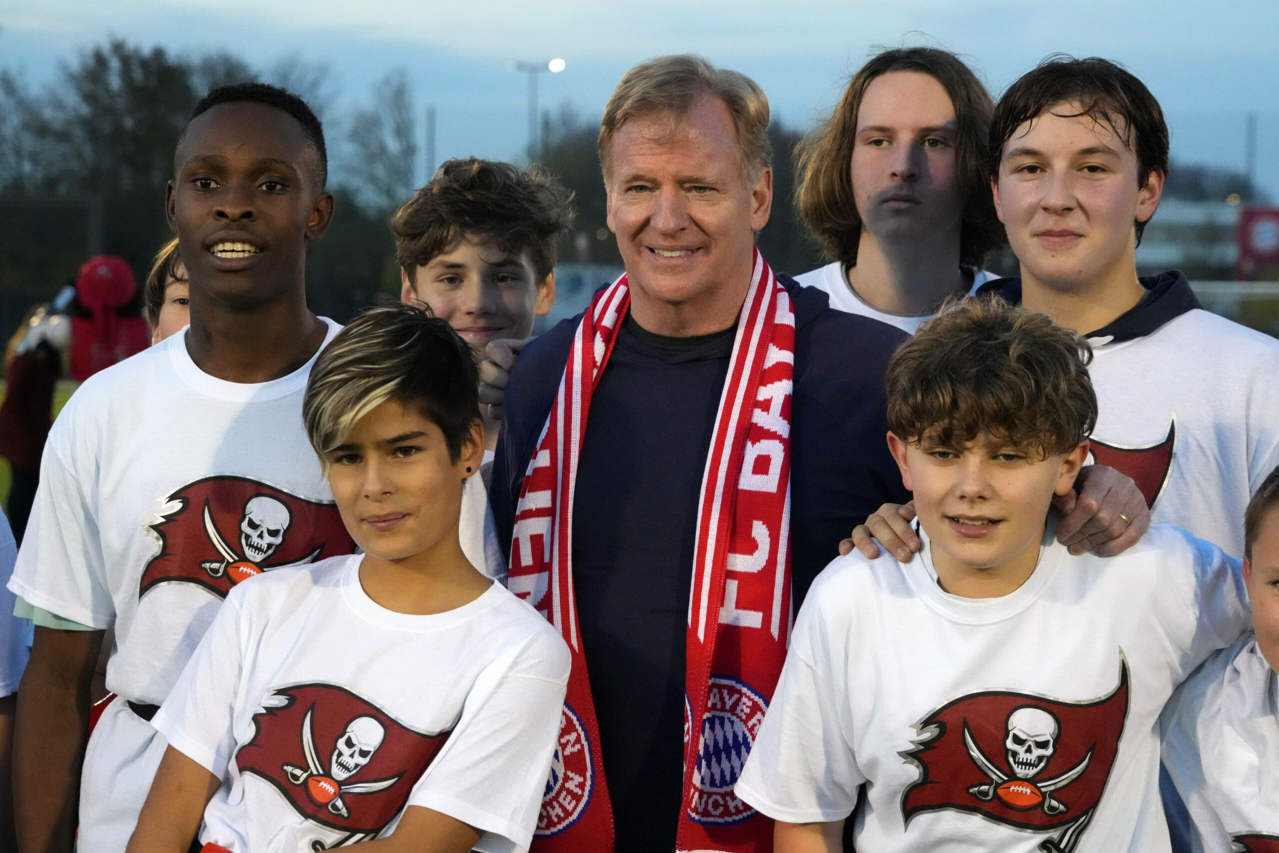 Roger Goodell posiert im Bayern-Schal mit Kindern.