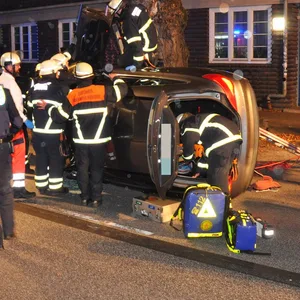 Rettungskräfte stehen um ein Auto in Eimsbüttel, das auf der Seite liegt