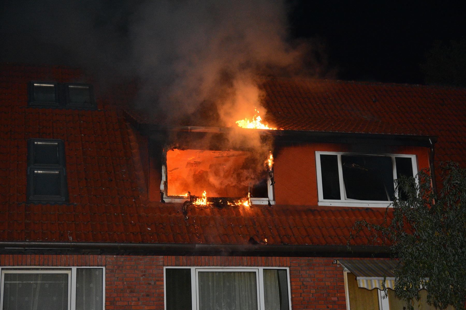 Flammen züngeln aus der Wohnung. Drei Menschen kamen ins Krankenhaus.