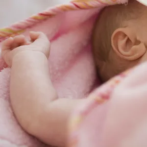 Schlafendes Baby unter einer rosafarbenen Decke