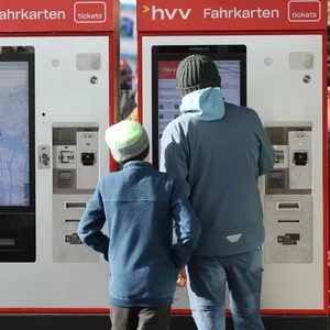 Zwei Personen stehen an einem Fahrkartenautomaten des HVV. (Symbolbild)