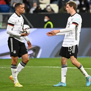 Lukas Nmecha gibt Thomas Müller vor einem Strafstoß den Ball.