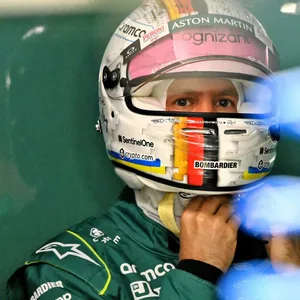 Sebastian Vettel setzt sich seinen Helm auf.