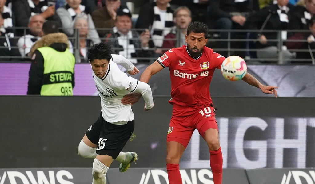 Daichi Kamada im Zweikampf mit Leverkusens Kerem Demirbay