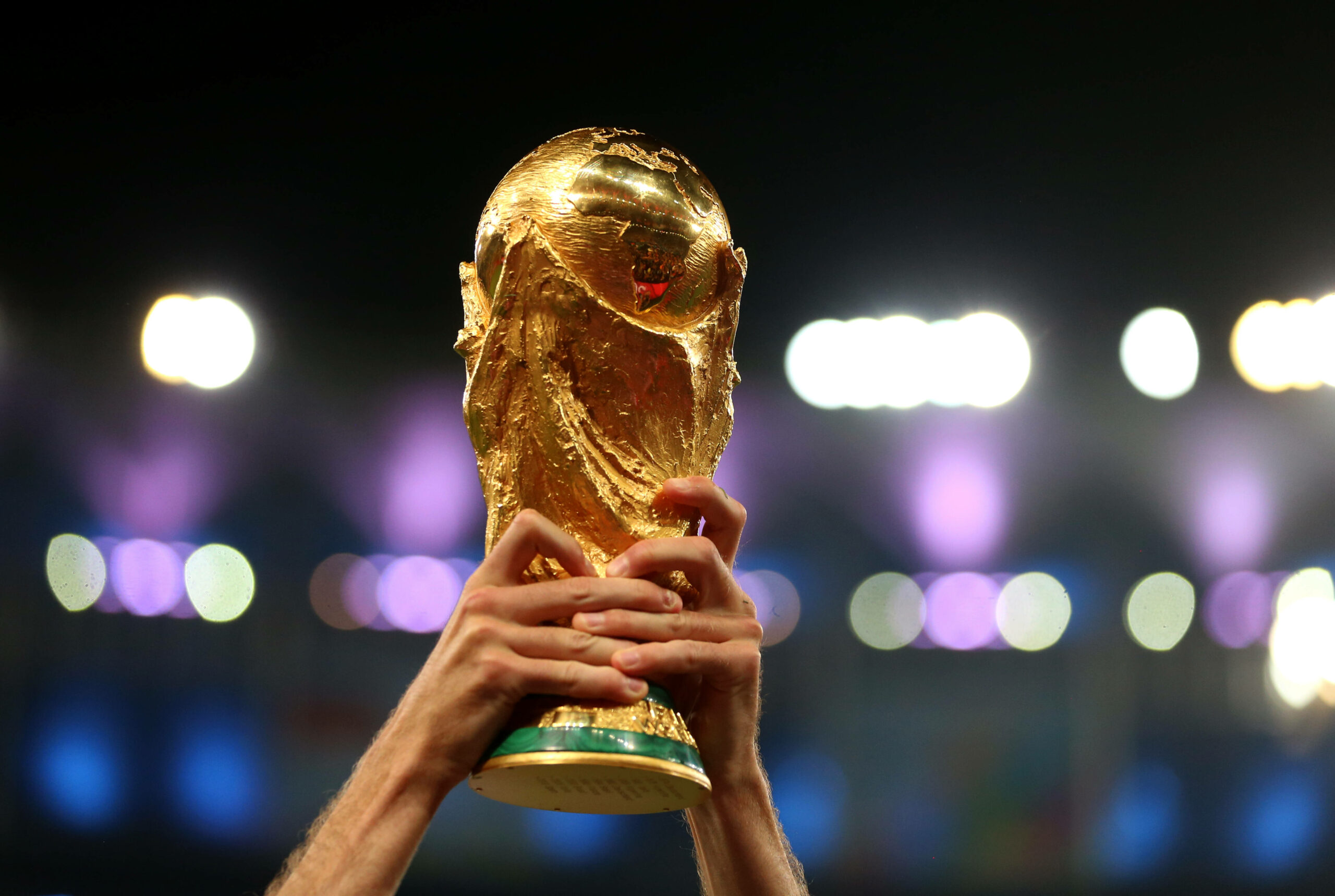 Ein Fußballspieler stemmt den WM-Pokal in die Lüfte