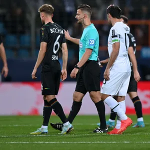 Schiedsrichter Daniel Schlager hat Kontakt zum VAR. Die Gladbacher Spieler können es nicht fassen.