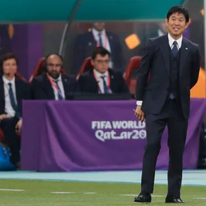 Japans Nationaltrainer Hajime Moriyasu mit einem breiten Lächeln während dem Spiel gegen Deutschland.