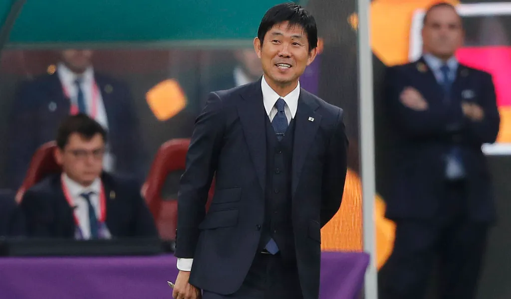 Japans Nationaltrainer Hajime Moriyasu mit einem breiten Lächeln während dem Spiel gegen Deutschland.