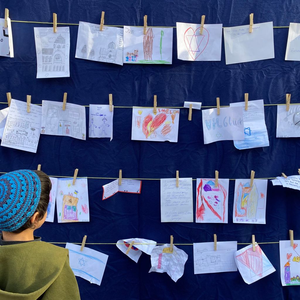 Ein Junge schaut sich die bunten Zeichnungen seiner Mitschüler an.