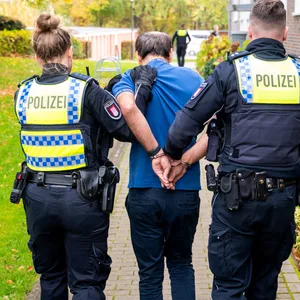 Der Ex-Mann der getöteten zweifachen Mutter wird von Polizisten abgeführt.