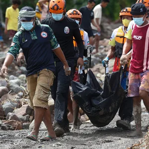 Rettungskräfte tragen eine Leiche, die sie nach dem Tropensturm „Nalgae“ im Süden der Philippinen geborgen haben.