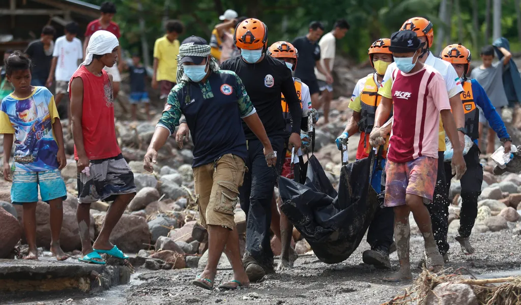 Rettungskräfte tragen eine Leiche, die sie nach dem Tropensturm „Nalgae“ im Süden der Philippinen geborgen haben.