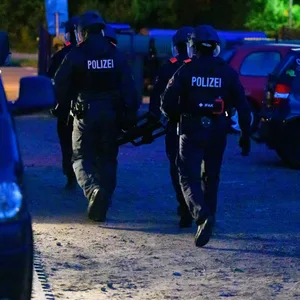 Polizisten verlassen nach einer Durchsuchung ein Wohngebiet.