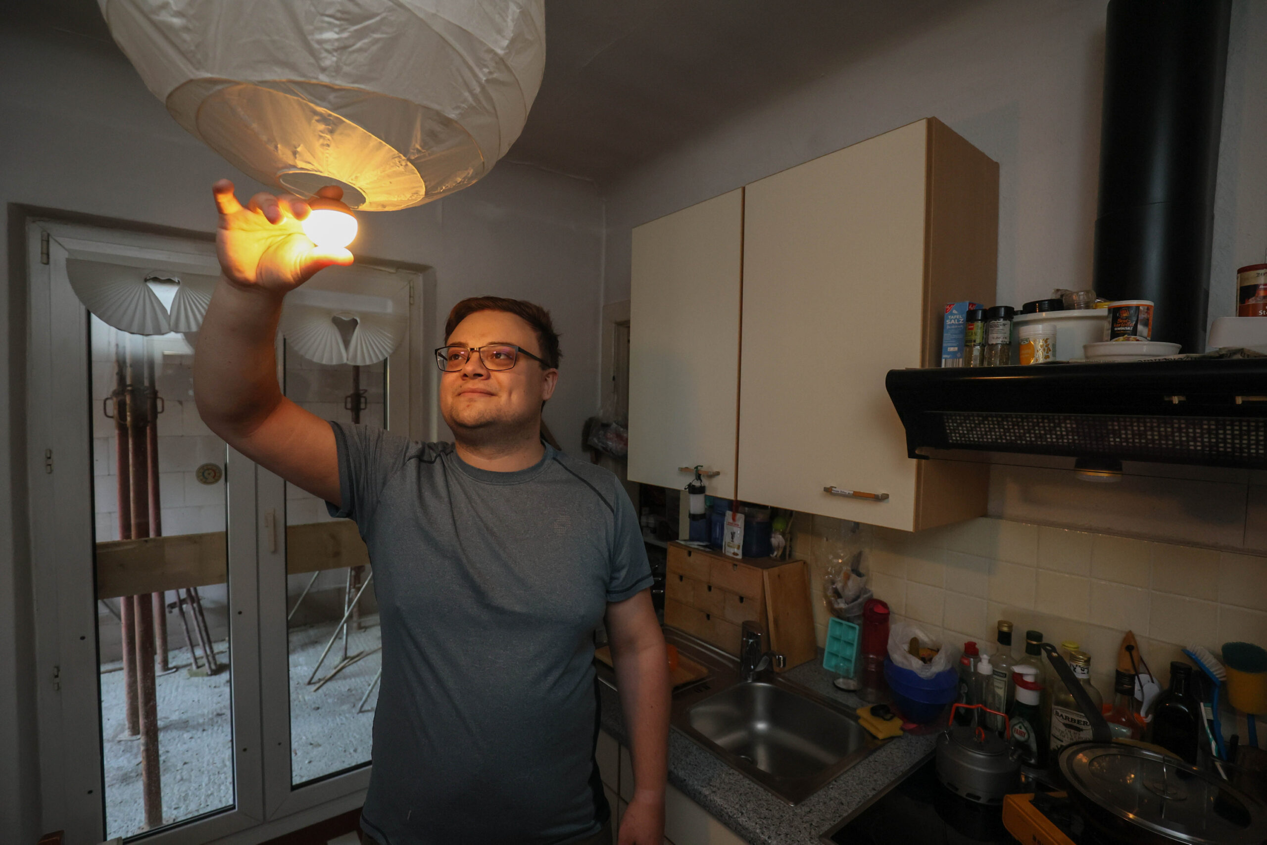 Jean Geuder (28) in der  Küche ohne Strom. Hier behilft sich die Familie mit Camping-Lichtern.