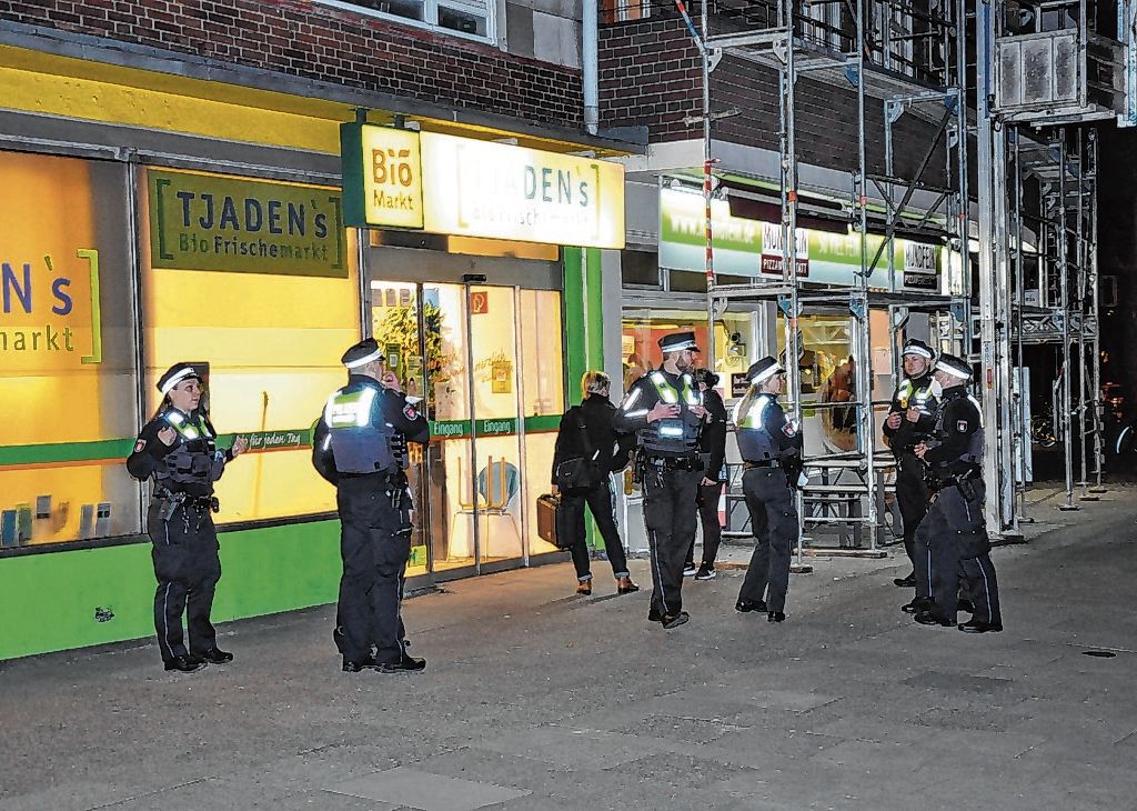 Polizisten stehen vor einem Tjadens Biomarkt