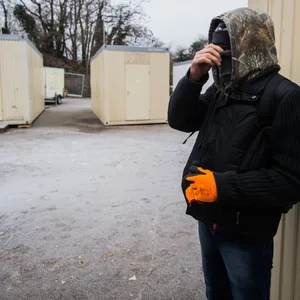 Ein Obdachloser zwischen Wohncontainern, die als Schlafplätze dienen.
