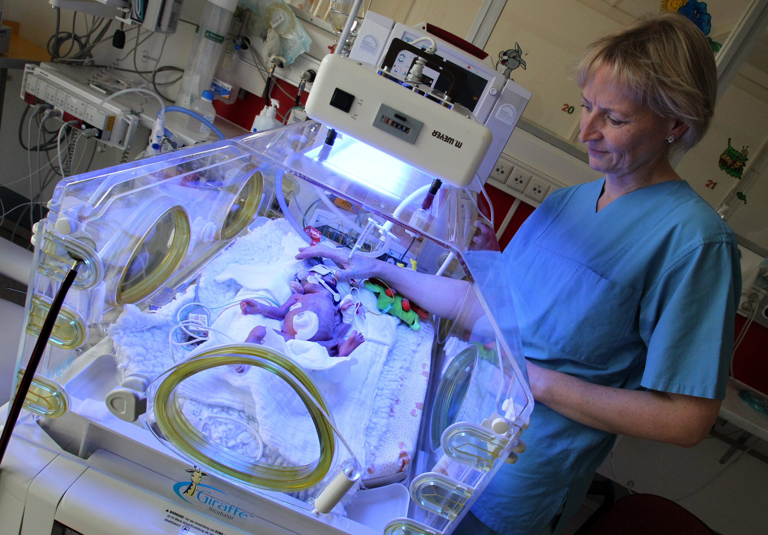 Auf der Pädiatrischen Intensivstation des Dietrich-Bonhoeffer-Klinikums in Neubrandenburg versorgt eine Krankenschwester ein Frühchen im Inkubator. (Archivbild)