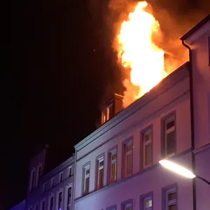 Flammen schlagen aus einer Dachgeschosswohnung