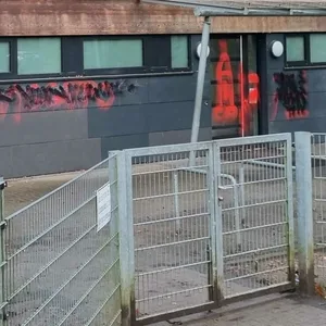Die Turnhallenwand mit Schriftzügen und Symbolen.