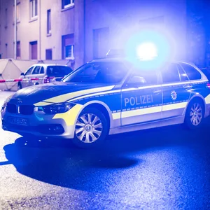 Polizeiwagen steht vor Haus