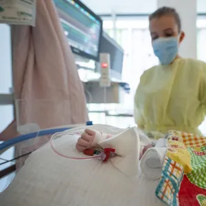 Eine Intensivpflegerin versorgt auf einer Kinder-Intensivstation einen am RS-Virus erkrankten Patienten, der beatmet wird.