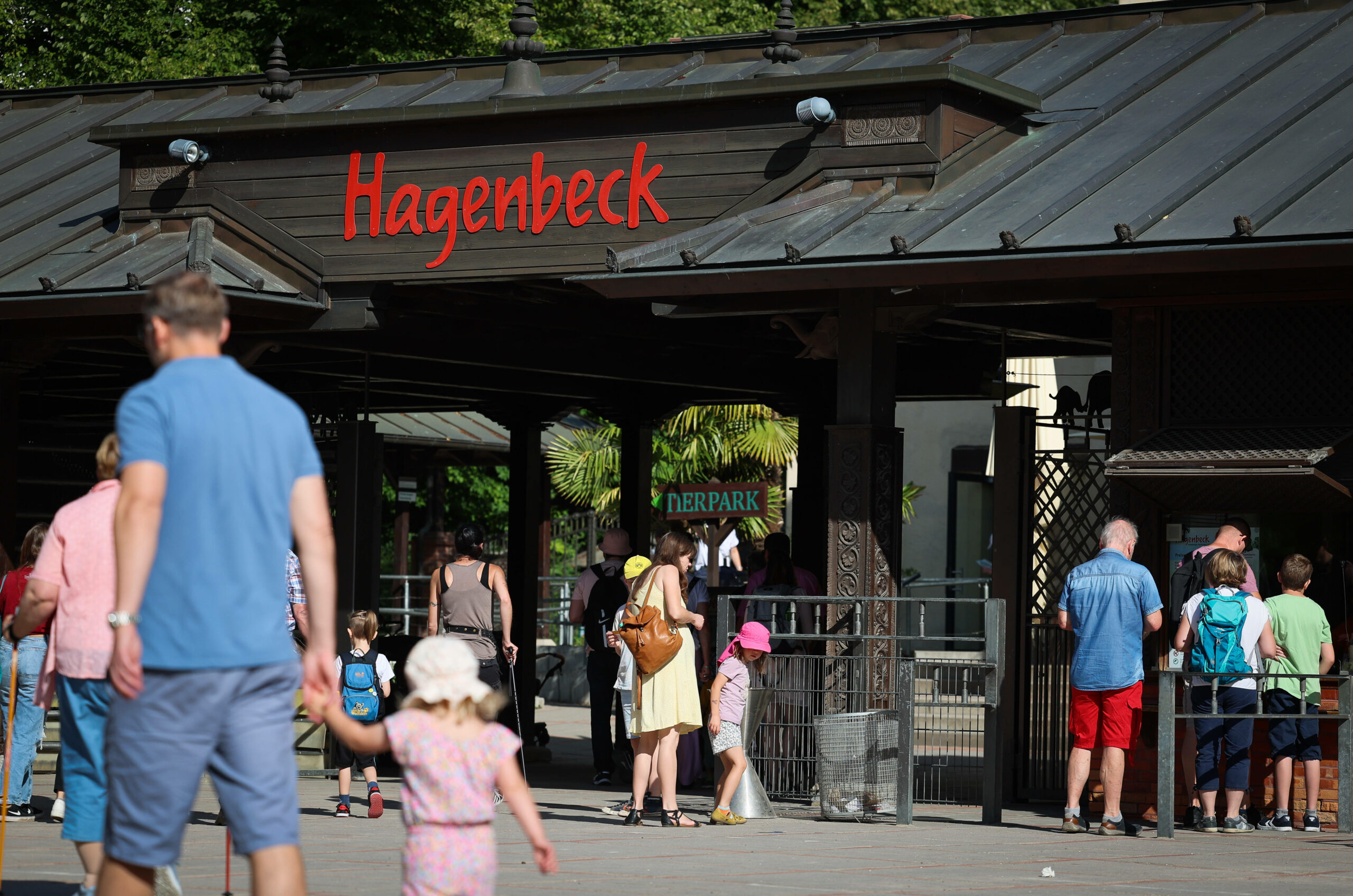 Besucher gehen bei sommerlichen Temperaturen in den Hamburger Tierpark Hagenbeck.