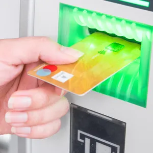 Eine Girocarte mit blaut-rotem Maestro-Logo wird in einen Geldautomaten gesteckt.