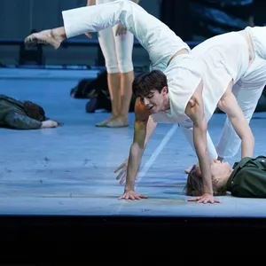 Balletttänzer in weiß tanzen auf der Bühne. Unter ihnen liegen Soldaten
