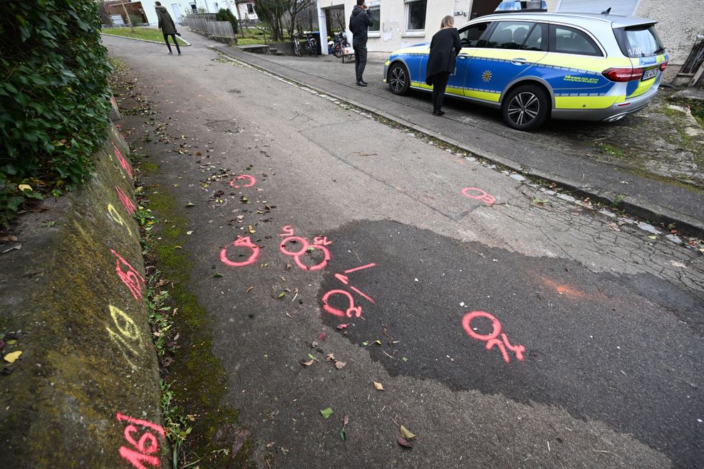 Markierungen der Spurensicherung der Polizei sind an einem Tatort auf einem Weg angebracht.