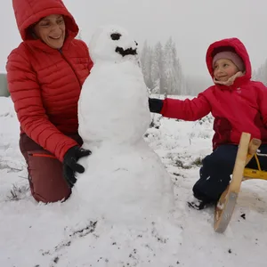 Eine Frau baut mit ihrer Tochter einen Schneemann am Hexenritt in Braunlage.