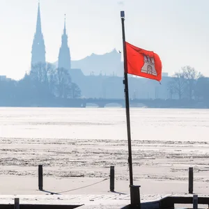 Eine Hamburg-Flagge vor den Wahrzeichen Hamburgs