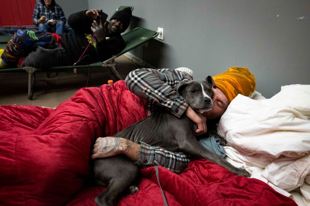 Thomas Dameron umarmt seinen drei Monate alten Welpen Rello in einer Notunterkunft für Obdachlose in der Action Church, während einer Kältewelle in den USA.