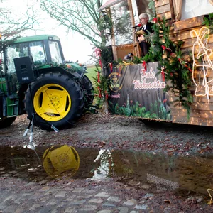 Robert Vetter, Pastor der evangelischen Kirchengemeinde Stuhr, spricht während eines Gottesdienstes an Heiligabend von seinem Anhänger mit Waldhütte, der von einem Traktor gezogen wird.